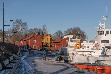 Harbor view with commuting boats in the district town of Vaxholm a sunny winter day in the archipelago of Stockholm