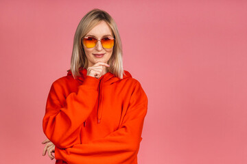 Portrait of a young beautiful cute cheerful blonde woman smiling looking at the camera isolated over pink background.