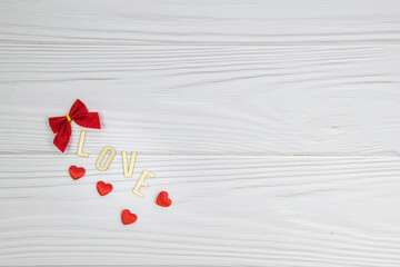 Valentine's day, love on a light background. Wooden inscription love. Red hearts and lights. Romantic background