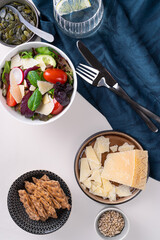 Fresh mixed salat with   tomatoes. Healthy food concept. Top view on table with bread,olive oil,cheese,sunflower seeds and glass of water.