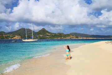 Young woman in bikini relaxing at the beach, White Island, Grenada.