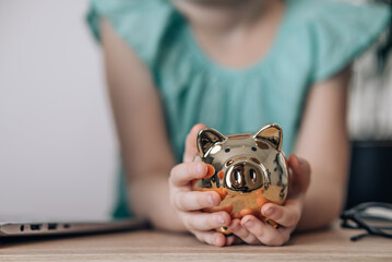 Family Economy. Little  caucasian girl holding piggy bank In hands