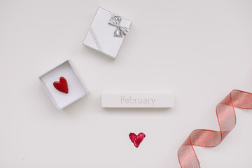  wedding ring and silver jewelry box on white background with red heart and red ribbon. The moment of a wedding, anniversary, engagement, or Valentine's Day. Happy day.