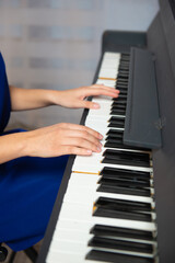 Fototapeta premium a girl plays the piano in a blue dress. High quality photo