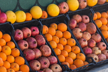 close-up fresh pomegranates and an orange lie in a basket
