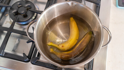 Boiled banana in the pot. High calories snack. Traditional Thai dessert. Boiled banana with banana leaf.