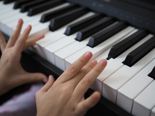 Fototapeta premium Close-up of a child's hand playing the piano . Favorite classical music. musical instruments for teaching music at home. The concept of a musical instrument. Self-education.
