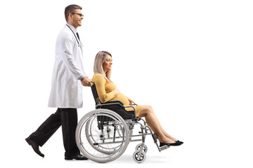 Full length profile shot of a doctor pushing a pregnant woman in a wheelchair