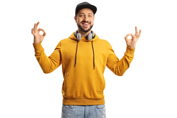 Fototapeta premium Smiling young man with headphones gesturing ok sign with both hands