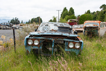 Antique cars on a big scrapyard at the end of Old Coach Road Trail, New Zealand