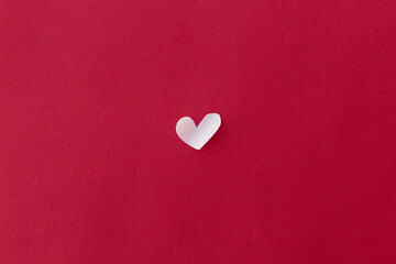 Obraz premium Happy Valentine's Day! Valentine heart flat lay on red background with space for text. Valentines day minimal card. Cute little white heart cut out on red paper. Love concept