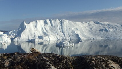 piękne kry i góry lodowe na spokojnym morzu odbijające się w tafli wody w słoneczny dzień