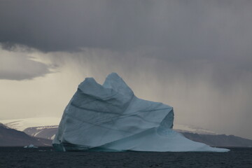 duże góry lodowe o różnych kształtach na morzu w pochmurny dzień - obrazy, fototapety, plakaty