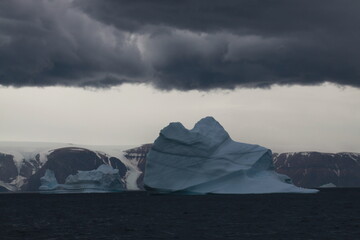 duże góry lodowe o różnych kształtach na morzu w pochmurny dzień - obrazy, fototapety, plakaty