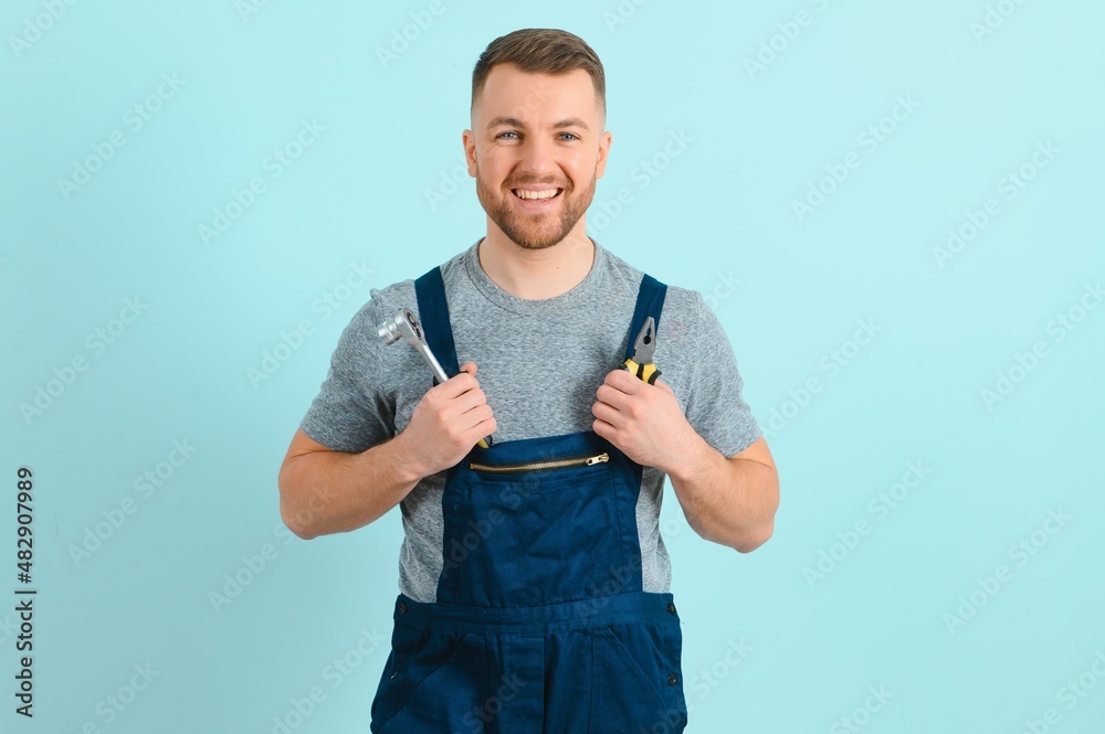 Wall mural Close-up portrait of his he nice attractive cheerful cheery content guy repairer craftsman isolated over blue color background.