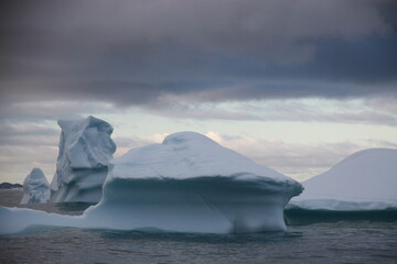 duże góry lodowe o różnych kształtach na morzu w pochmurny dzień - 482907913