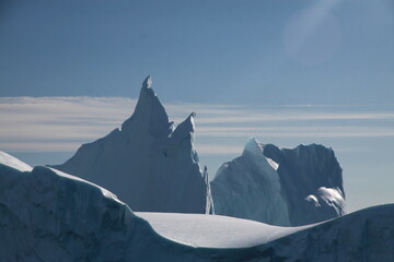 piękne i majestatyczne góry lodowe ukształtowane w fantazyjne formy w słoneczny dzień - obrazy, fototapety, plakaty