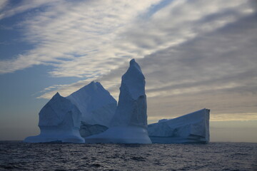 masywne bloki lodowe na morzu o zachodzie słońca - 482908969
