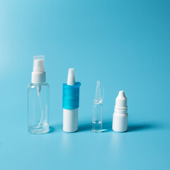 Nasal and eyes droppers on blue. Medicine drops in pumps and droppers. Nasal drops on blue background.