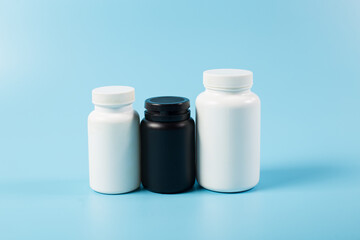 Different containers with blank. Plastic bottles for medicines. Medical containers on blue background.