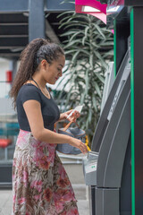 Young woman withdrawing money from an ATM.