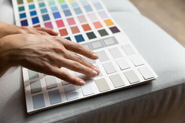 Unrecognizable female hands on paint swatches palette close up. Fashion designer woman use pantone samples choose color prepares for coming repairs works selecting wall colour, home renovation concept - Powered by Adobe