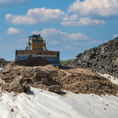 the process of leveling sand with a modern bulldozer during the construction of a dirt road