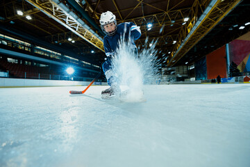 Boy playing ice hockey at indoors rink