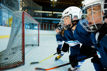 Boys playing ice hockey at indoors rink
