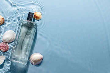 Perfume bottle on blue water wavy background with seashells. Fresh sea fragrance concept.
