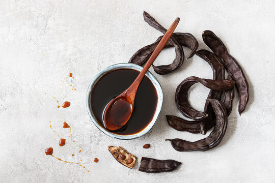Healthy organic sweet carob pods with seeds and syrup