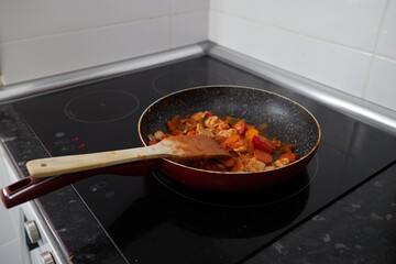 Frying pan with vegetables and a wooden shovel