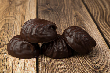 Marshmallows in chocolate on a wooden background.The dessert is delicious.