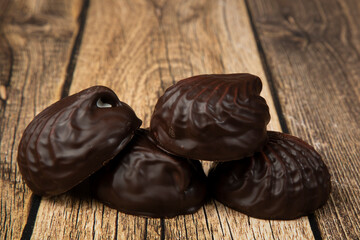 Marshmallows in chocolate on a wooden background.The dessert is delicious.