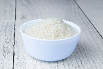 Golden rice in a white plate on a white background.