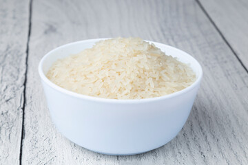 Golden rice in a white plate on a white background.