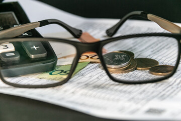 Glasses, Belarusian money, calculator and utility bill in the Republic of Belarus. The concept of paying utility bills and increasing prices. Close-up. Blurred background. Selective focus.