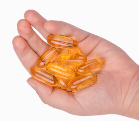 Close up of fish oil capsules on a hand isolated on white background