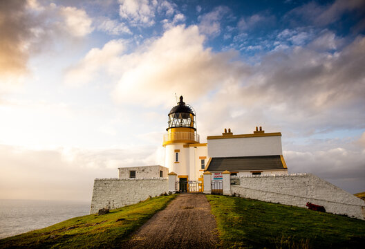 Stoer Lighthouse, Unapool, Scotland - Warm sunlight and clouds in the sky.