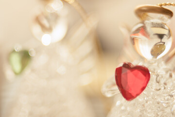 Transparent statuettes of small angels with hearts in their hands