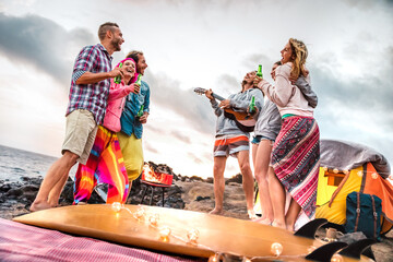 Young friends having fun at beach camping party - Wanderlust travel life style concept with happy...