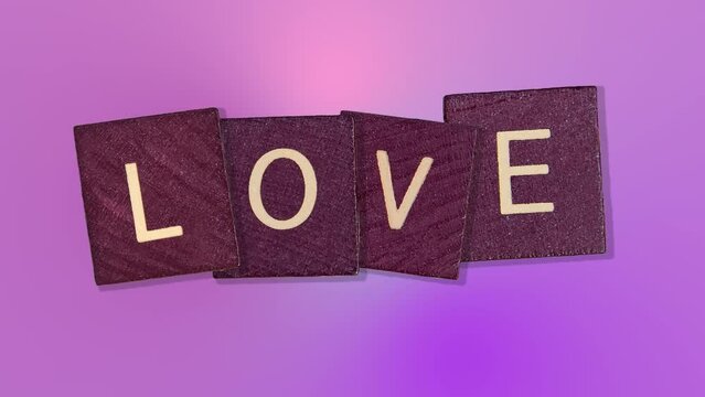 text - Love on Animated purple wooden blocks on trending pink multi colored animation background. High quality 4k motion design graphics art footage.Romantic Love concept for mother's, St. Valentine's