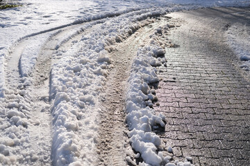 part of street in city, pavement after heavy snowfall, wet snow melts, puddles, slush and mud...