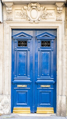 Paris, a blue wooden door, typical building in the center
