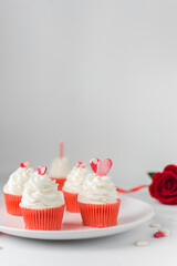 White and red cupcakes with a hearts on a white plate, white frosting on a red cupcake, valentines day cupcakes, valentine dessert