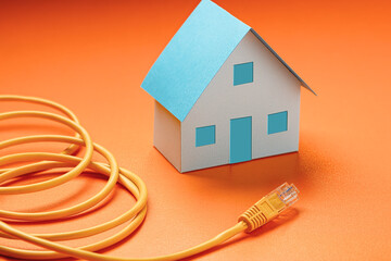 Paper model of a house and a network cable close-up