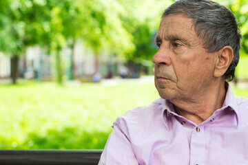 Fototapeta premium Senior man sitting on bench in the park