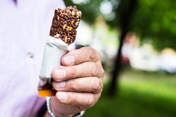 Active senior man eating a protein bar