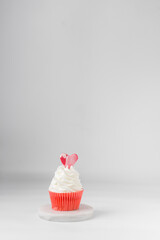White and red cupcake with a heart on a white background, white frosting on a red cupcake, valentines day cupcakes, valentine dessert