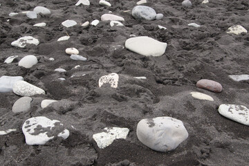 Kieselsteine auf dem schwarzen Sandstrand, Basaltstrand von Jökulsárlón ein Gletschersee im...